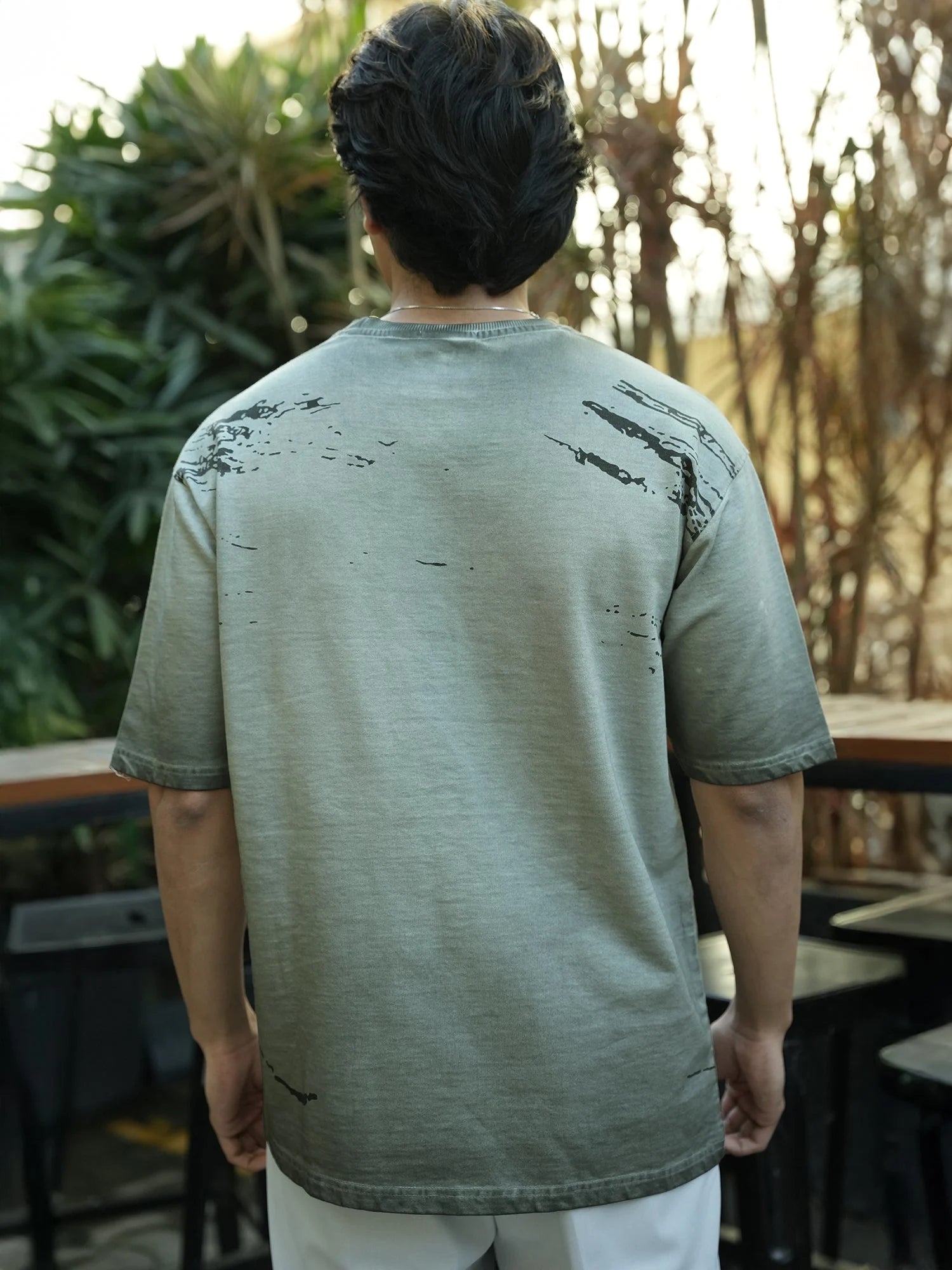 Men’s grey oversized cotton printed T-shirt paired with cargo pants and sneakers for urban fashion style